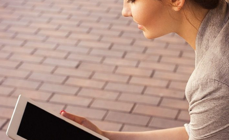 Photo of a woman looking at a tablet